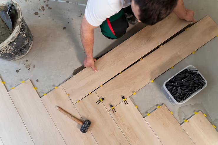 Overhead view of a professional tiling a floor